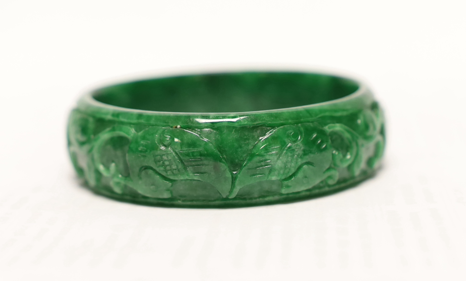 A Chinese carved jadeite bangle, 7.5cm in diameter